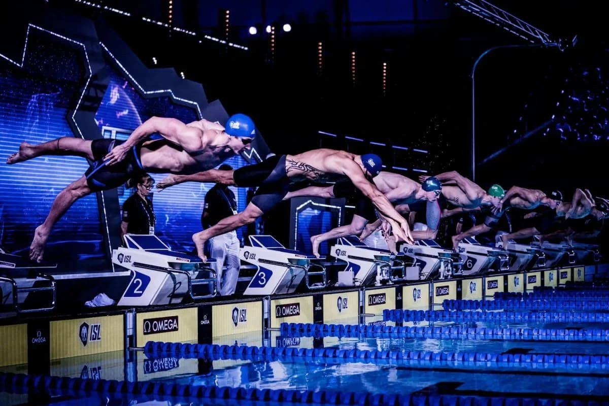 Swimmers diving from starting blocks during an ISL match at the London Aquatics Centre in November 2019